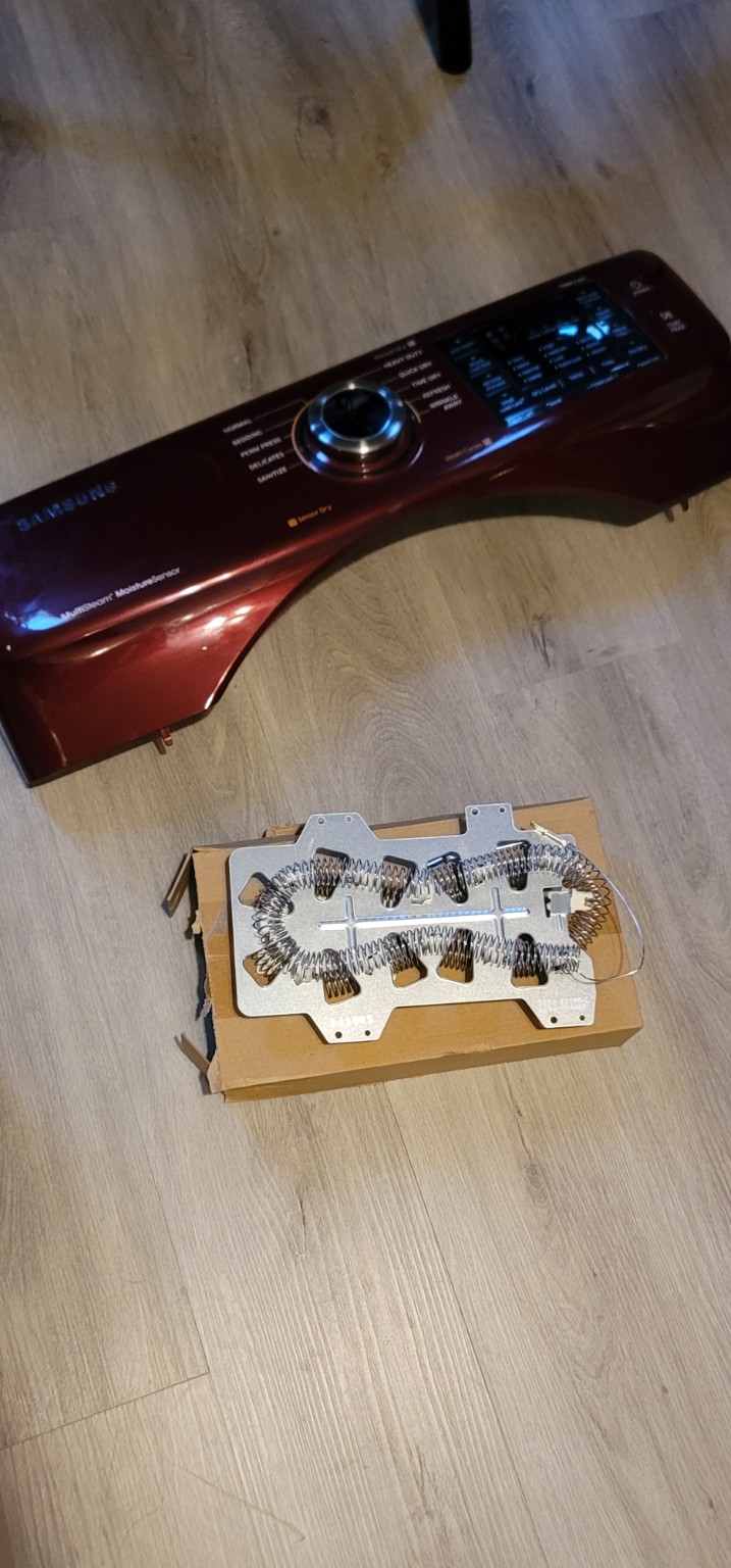 Samsung dryer control panel removed, with a replacement heating element ready for installation.